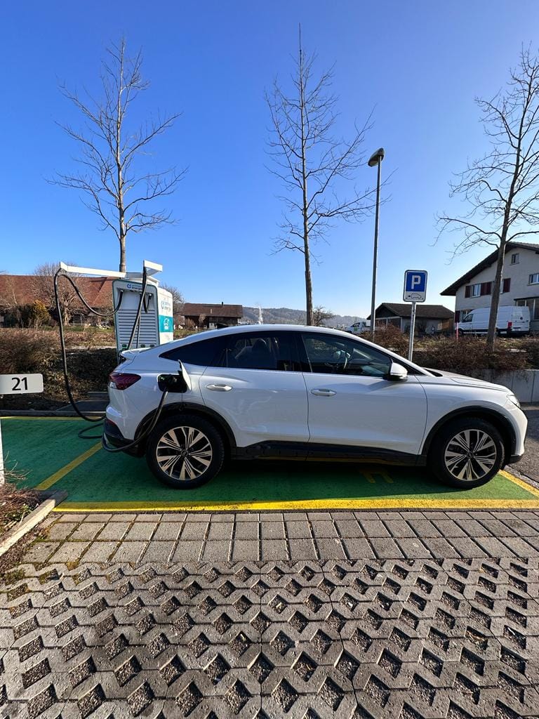 ngecas mobil listrik di swiss dengan latar pemandangan yang indah